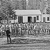 Students in cadet uniforms in front of the buildings, Indian training school, Forest Grove, Oregon