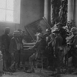 Squad of American soldiers listening to one of their comrades playing the organ in the half-wrecked old church in Exermont, in the Argonne. France, October 11, 1918. Sergeant J. A. Marshall.
