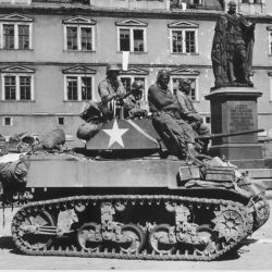 Crews of U.S. light tanks stand by awaiting call to clean out scattered Nazi machine gun nests in Coburg, Germany