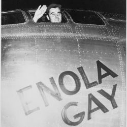 Colonel Paul W. Tibbets, Jr., pilot of the ENOLA GAY, the plane that dropped the atomic bomb on Hiroshima, waves from his cockpit before the takeoff. Army Air Forces.
