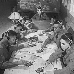"Basic and advanced flying school for Negro Air Corps cadets, Tuskegee, Alabama... In the center is Capt. Roy F. Morse, Air Corps... He is teaching the cadets how to send and receive code."
