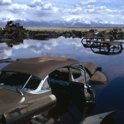 Abandoned Automobiles and Other Debris Clutter an Acid Water and Oil Filled Five Acre Pond