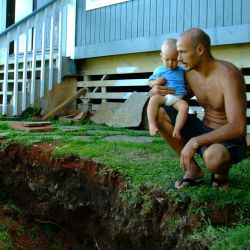 [Earthquake] Kapaau, HI, October 25, 2006- Oliver Kolly with son Oliver inspect the changed landscape in their backyard after a series of earthquakes struck this region. Adam DuBrowa/FEMA.