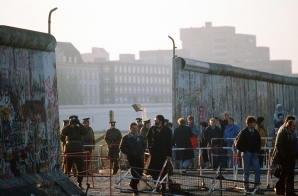 East German Police Watch as Visitors Pass Through the Berlin Wall