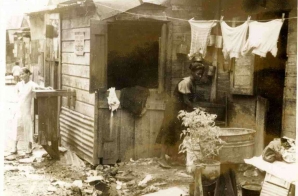 Woman Washing Clothes Outside a Shack