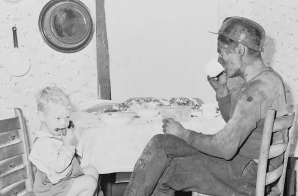 Rufus Sergent, miner, and his son have a bit to eat after work