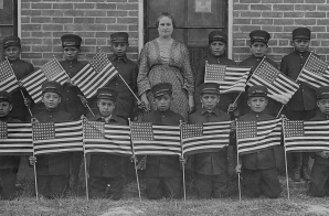 Very early class of young boys with flags at the Albuquerque Indian School
