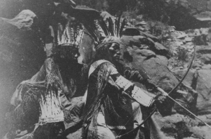 A Paiute drawing his bow and arrow; two others in festive costume