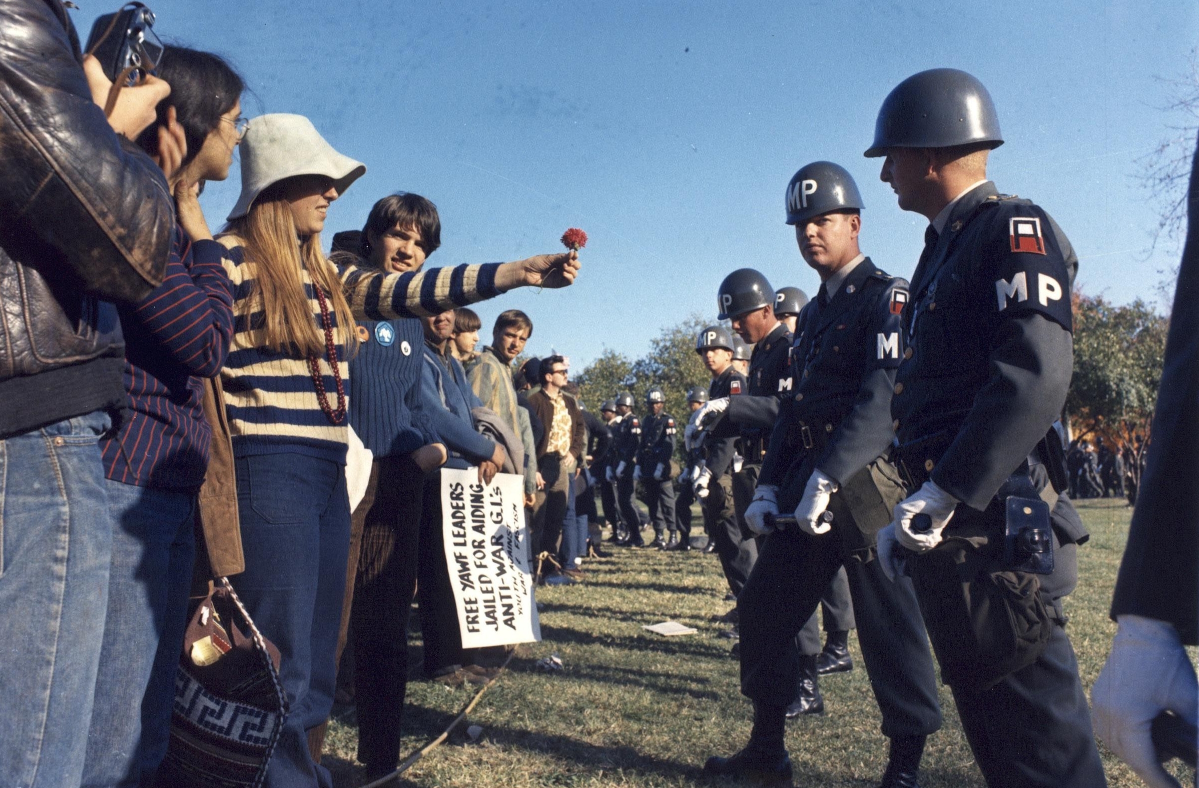 A Demonstrator Offers a Flower to a Military Police Officer