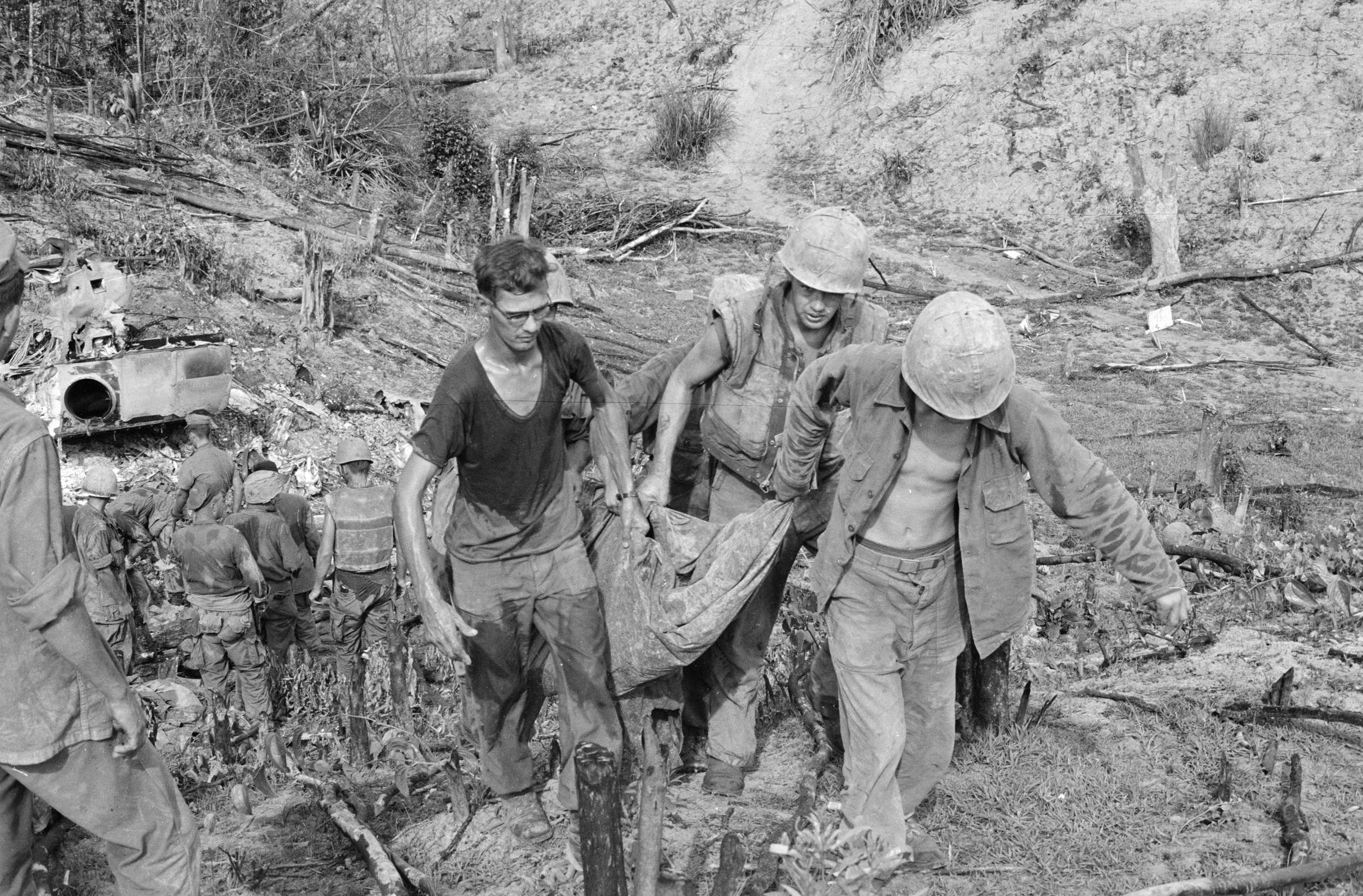 Marines Carry a Body From a CH-46 Helicopter Which was Shot Down and Burned