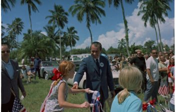 President Nixon greeting children in the waiting crowd at the Crandon Boulevard Fourth of July Parade route in Key Biscayne. July 4, 1969.